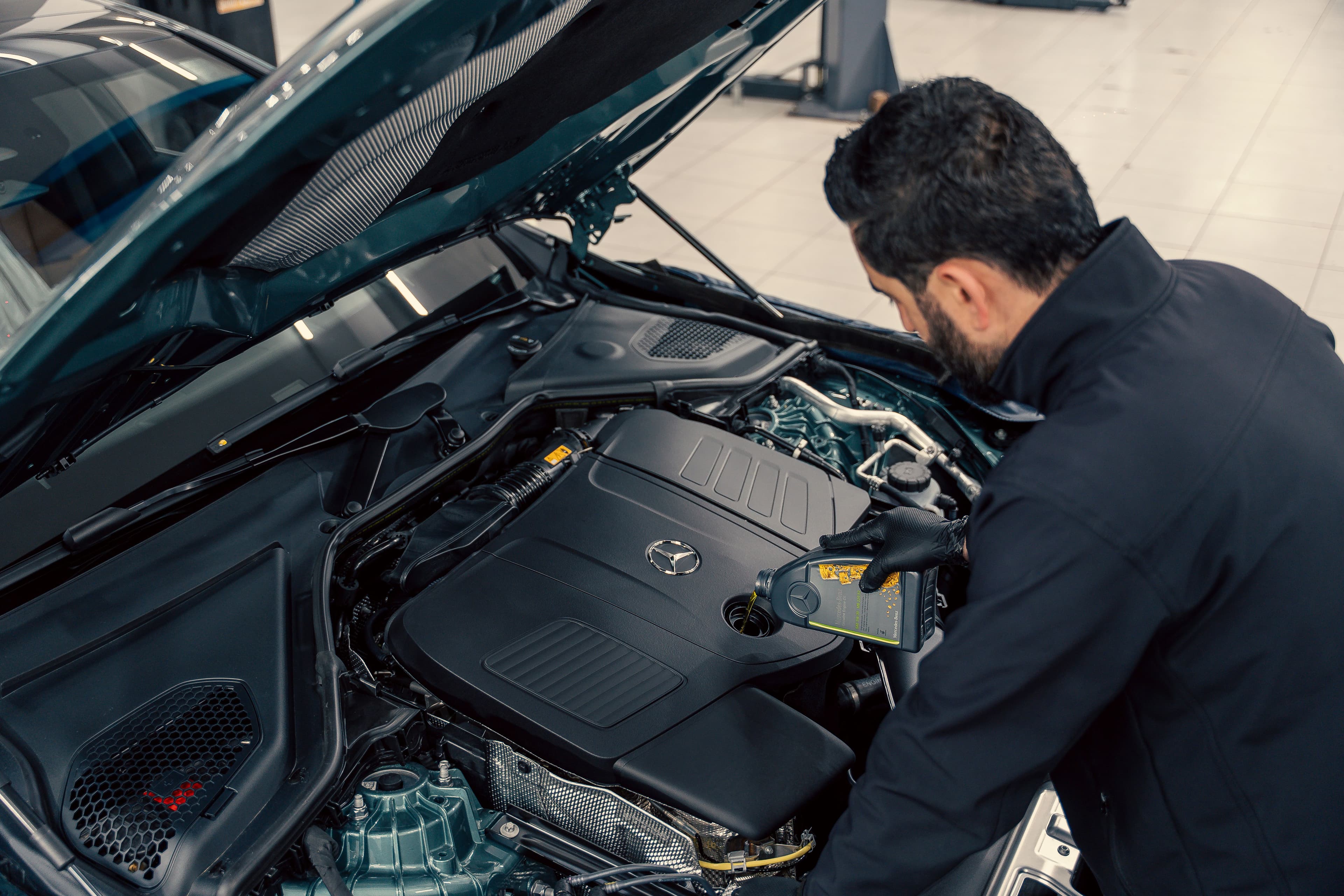 Mechanic pouring oil into engine