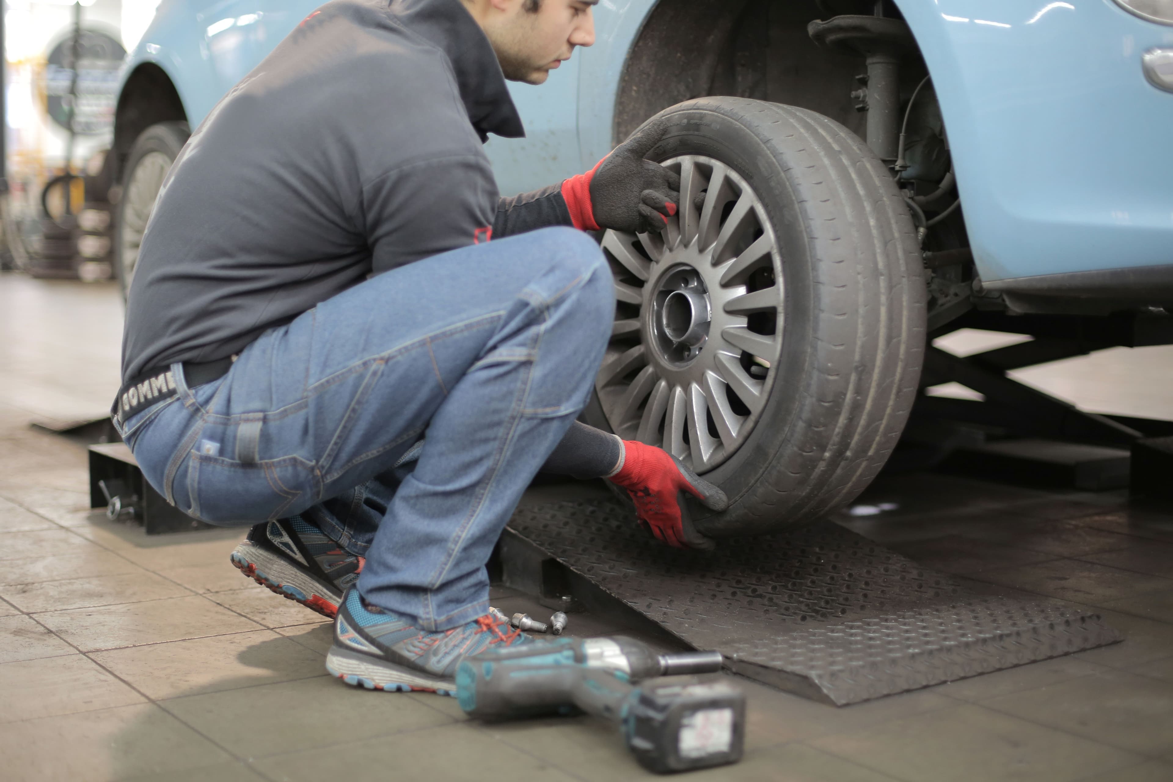 Mechanic performing wheel balancing